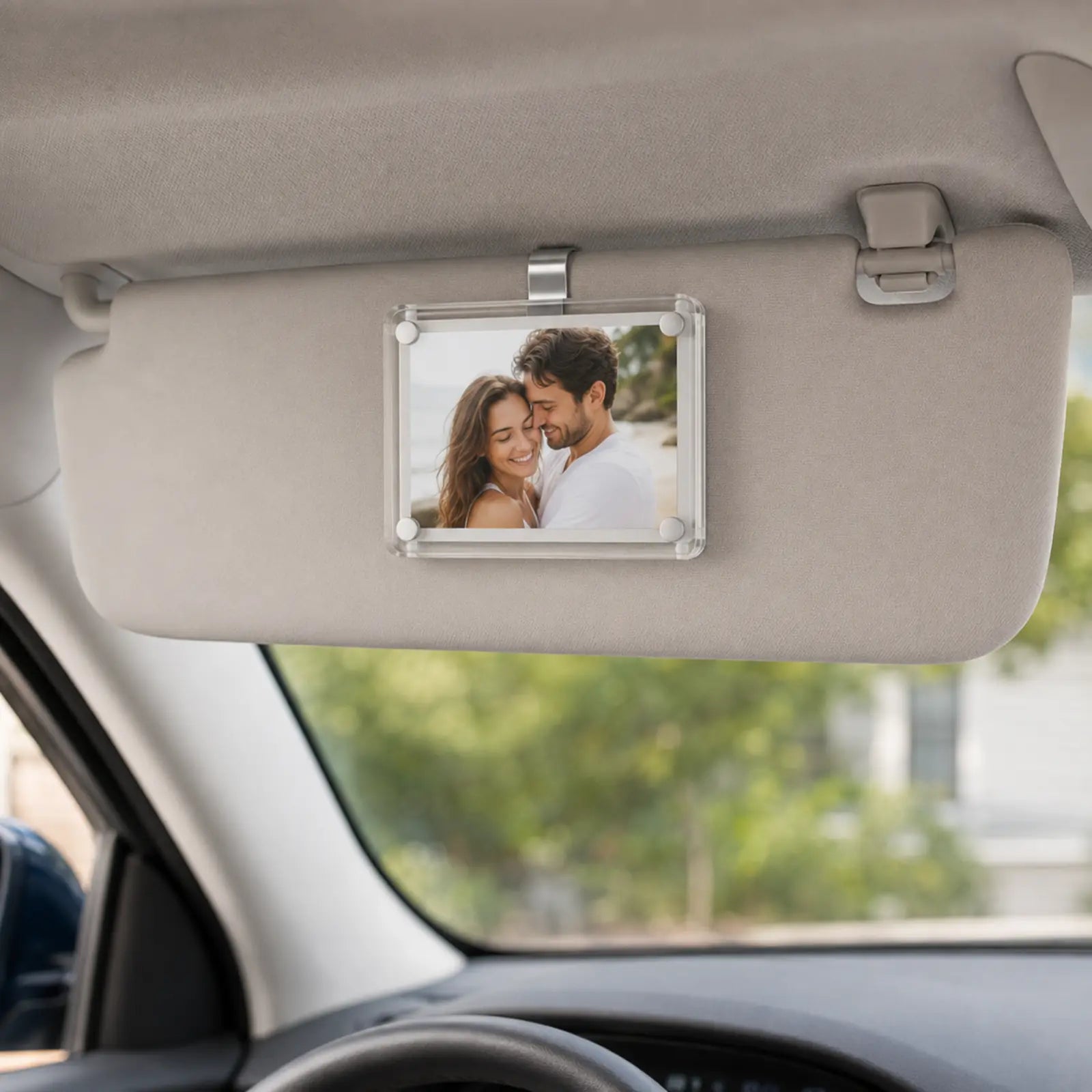 Looma CloseBy photo frame clipped to a car sun visor with a personal photo displayed.