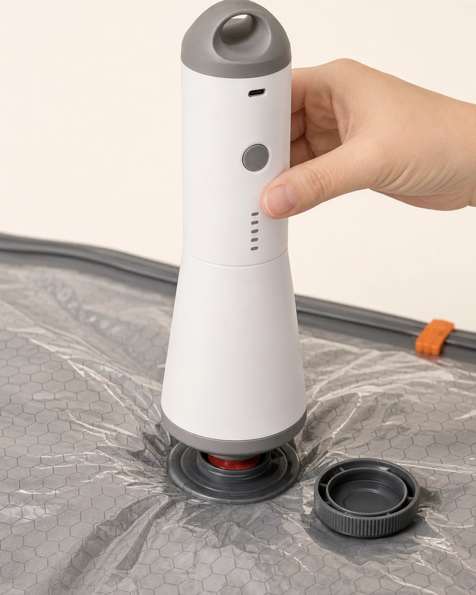 Close-up of the white and gray SG-508 pump connected to a black valve on a gray compression bag.
