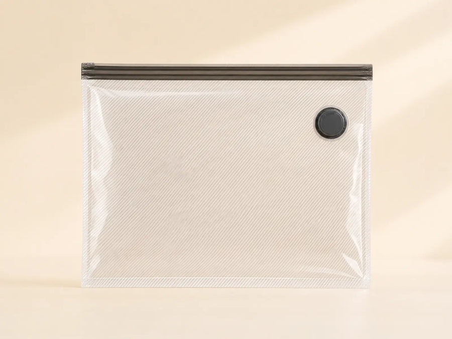 Clear ribbed 24-inch travel compression bag with a dark double-zip closure and black valve.