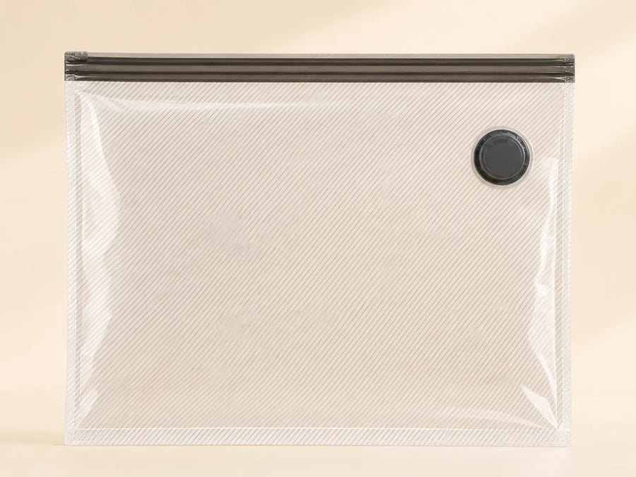 Clear ribbed 30-inch travel compression bag with a dark double-zip closure and black valve.