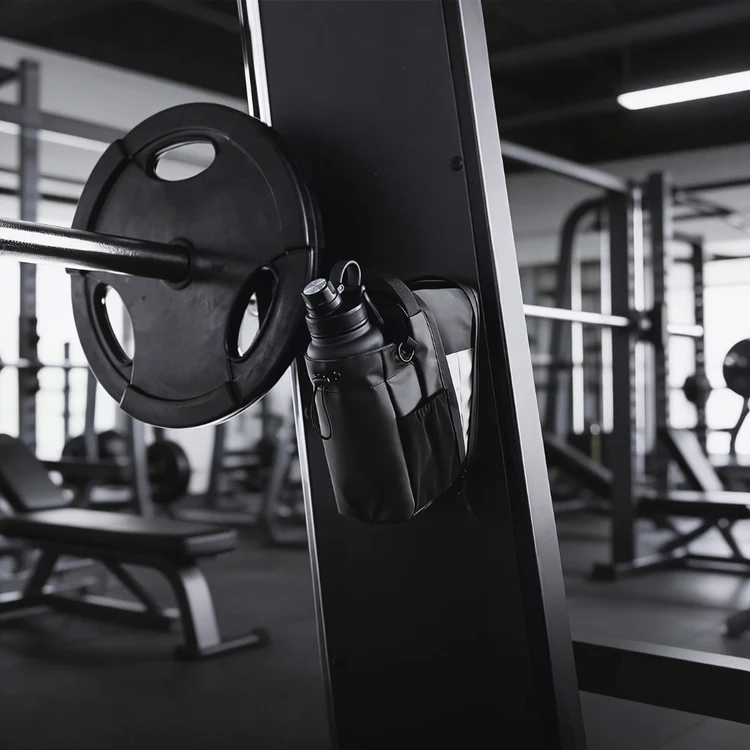 Black magnetic gym bag attached beside a weight plate on compatible steel gym equipment