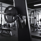 Black magnetic gym bag attached beside a weight plate on compatible steel gym equipment